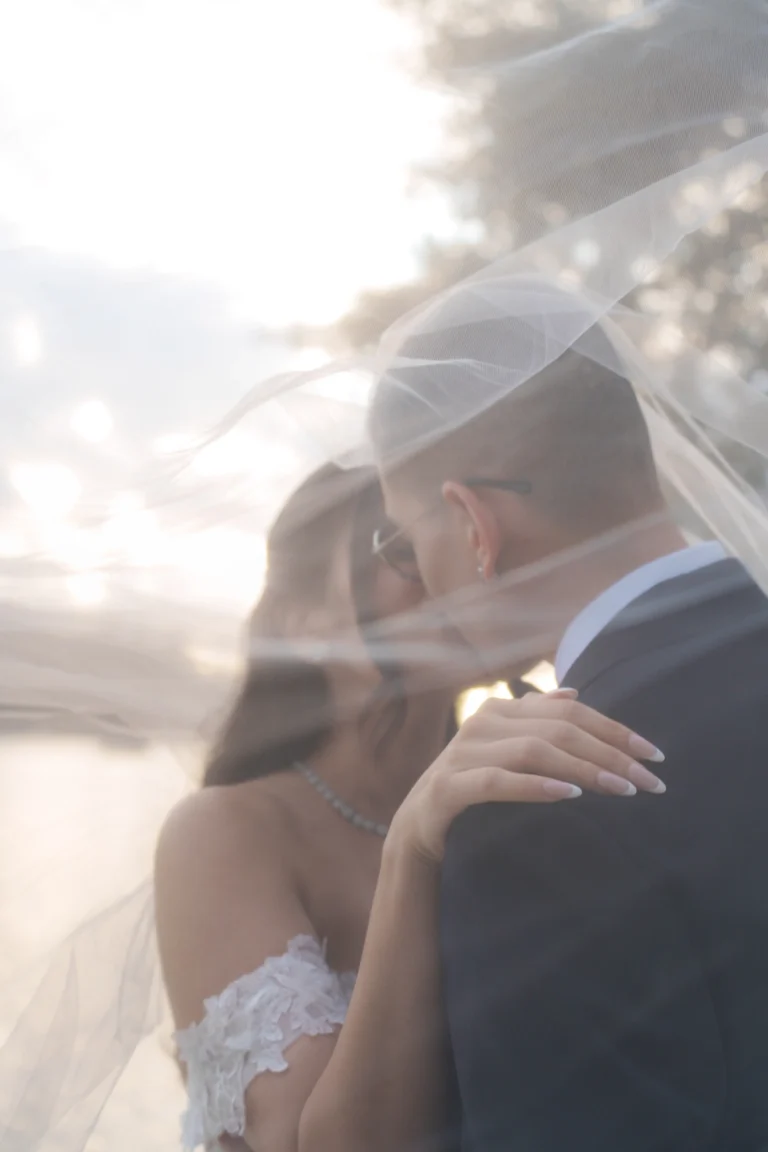Creative bride and groom portrait photographed through the wedding veil